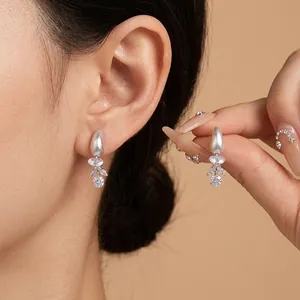 Elegant silver water-drop stud earrings with shimmering crystal tassels worn by model