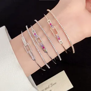 Detail view of 18k gold plated square link bangles with colorful zircons on wrist