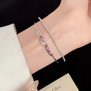 Detail macro view of 18k gold plated bangle with multi-colored square zircons on wrist