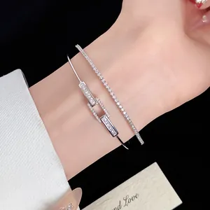 Close-up detail of 18k gold plated zircon square open bangle and tennis bracelet on wrist