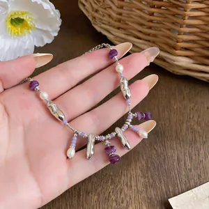 Detail view of the beaded necklace featuring purple acrylic beads and white pearls.