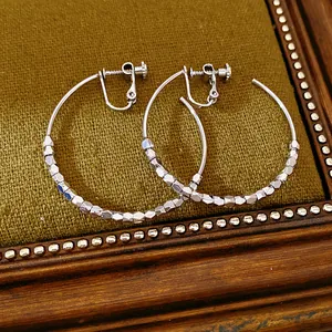 Close-up detail of silver faceted bead clip-on hoop earrings for non-pierced ears in 14K gold