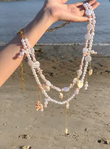 Bohemian beach body chain with pink pearls and seashell charms for vacation wear