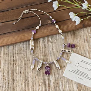 Detail view of a purple beaded necklace with silver accents and pearls on rustic background