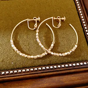 Macro view of 14K gold plated faceted bead hoop ear clips for non-pierced ears style