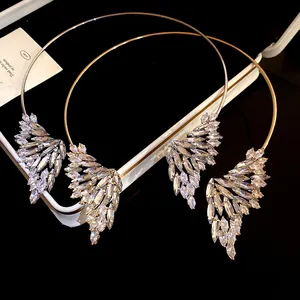 Dettaglio ravvicinato di eleganti girocolli ad ala in oro e argento con cristalli