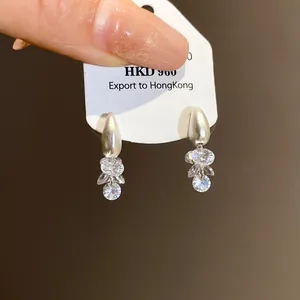 Detailed view of silver-toned dangle earrings with shimmering clear crystals