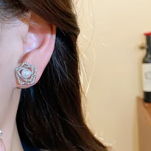 Macro detail view of an elegant 14k gold plated flower pearl earring worn on the ear