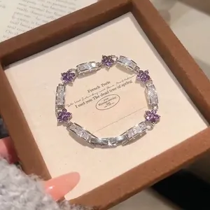 Detailed close-up of a delicate floral zircon bracelet presented in a brown jewelry box.
