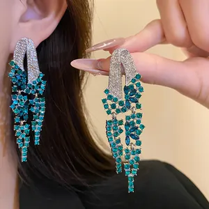 Detailed close-up view of elegant emerald green rhinestone tassel drop earrings