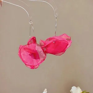 Nahaufnahme der leuchtend rosa Schiffon-Blütenblätter an eleganten Ohrhaken-Ohrringen.