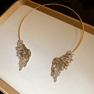 Dettaglio del girocollo dorato elegante con ali scintillanti e strass di qualità.