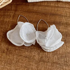 Detaillierte Ansicht eleganter weißer Chiffon-Blütenblätter an silbernen Ohrhaken.