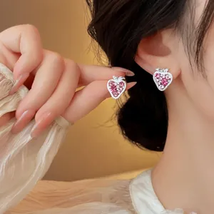 Close-up detail showing the elegant pink zircon strawberry stud earrings worn on ear