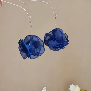 Detailansicht von königsblauen Chiffon-Blumenohrringen mit feiner Stoffstruktur
