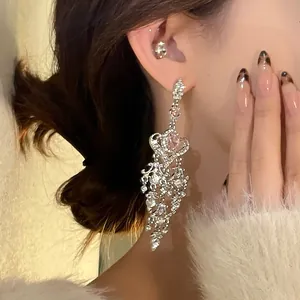 Detailed view of silver heart earrings with rhinestones and elegant tassels