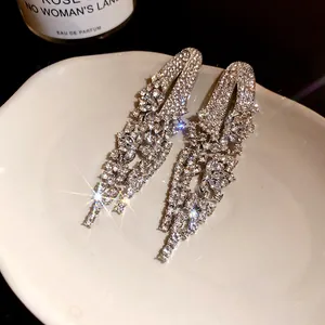 Elegant silver-tone geometric tassel earrings with sparkling rhinestones in a macro detail view