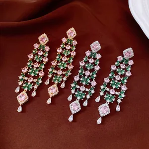 Détail de boucles d'oreilles pompons à fleurs en zircon plaqué or 18 carats.