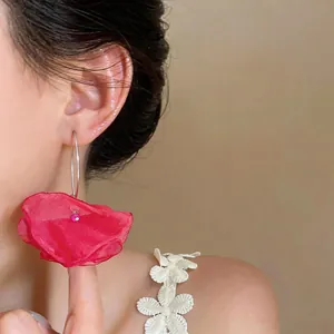 Detailansicht der eleganten roten Chiffon-Blumen-Creolen, getragen von einem Model