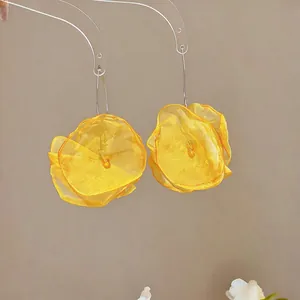Exquisite Detailaufnahme von gelben Chiffon-Blumenohrringen mit eleganten Metallhaken