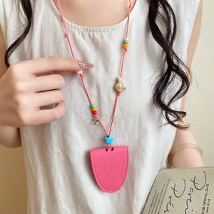 Close-up of pink leather glasses clip necklace with shell and starfish charms on a model.