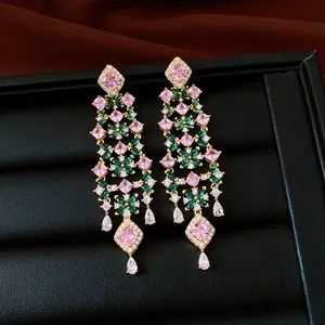 Gros plan de luxueuses boucles d'oreilles fleurs plaquées or 18k avec des zircons roses.