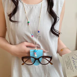 Close-up of a stylish eyeglass clip necklace with blue leather pouch and beads