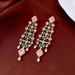 Vue détaillée de boucles d'oreilles fleurs élégantes en zircon rose et vert, plaquées or.