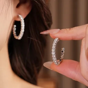 Detailed shot of silver-plated C-shaped earrings featuring brilliant cubic zirconia