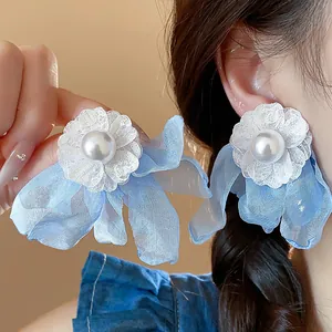 Detailed macro view of light blue chiffon flower earrings with central white pearls