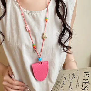 Detail view of a pink leather sunglasses holder necklace worn as a stylish accessory.