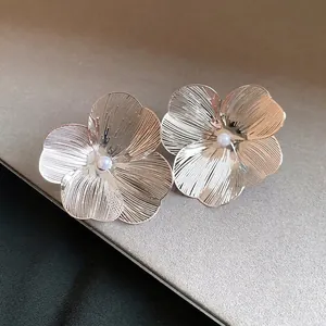 Elegant silver brushed metal flower ear clips with central pearl accents for a luxury look