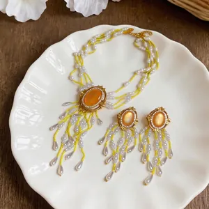 Vintage-Schmuckset mit orangefarbenen Steinen und Fransen aus Perlen-Wassertropfen.