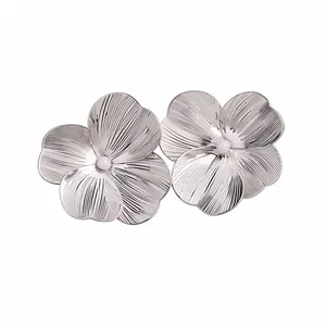 Elegant silver brushed metal flower ear clips jewelry with central white pearl accents.