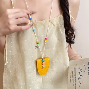 Close-up detail of a yellow leather starfish necklace with a portable sunglasses clip