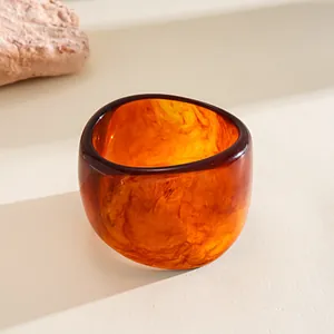 Macro view of wide irregular geometric resin bangle with amber texture