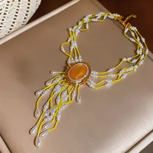 Elegante mehrlagige gelbe Perlenkette mit orangefarbenem Stein und Tropfenperlen-Quasten