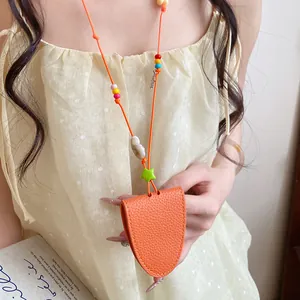 Close-up detail of the vibrant orange leather sunglasses holder necklace with colorful beads.