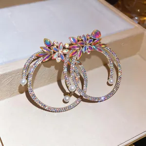 Detailed macro view of luxury rhinestone hoop earrings featuring floral accents and elegant pearls