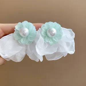 Detail showing the chiffon flower and pearl texture of the elegant earrings