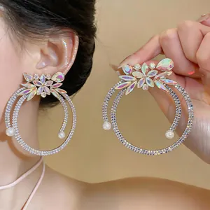 Detail shot of oversized rhinestone hoop earrings with iridescent stones and pearls