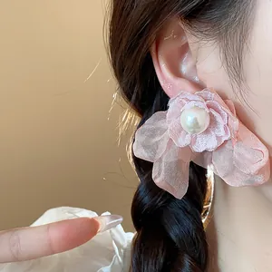 Detailed close-up view of a pink chiffon flower earring with an elegant pearl center