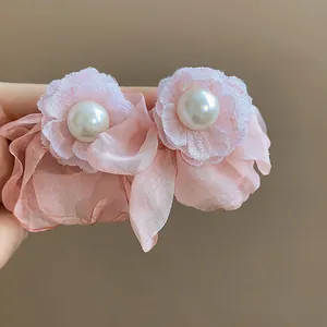Detail view of elegant pink chiffon flower earrings with central pearl embellishment
