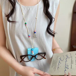 Detail of a blue leather eyeglass holder necklace with starfish charms and colorful beads.