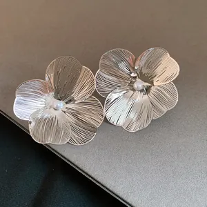Close-up macro view of exquisite silver brushed metal flower earrings with central pearl
