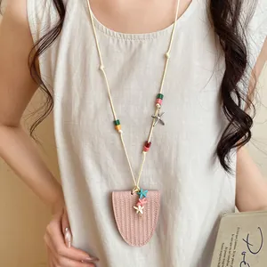 Detail view of a pink leather starfish glasses holder necklace worn over a linen top.
