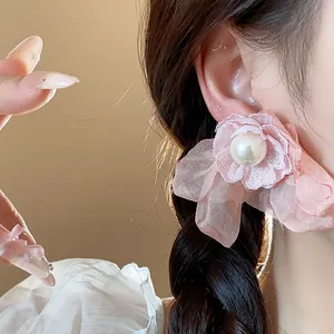 Detailed close-up of elegant pink chiffon flower earring with central white pearl accent