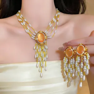 Vintage Schmuckset mit Perlenquasten und orangefarbenen ovalen Edelsteinen im Zentrum.