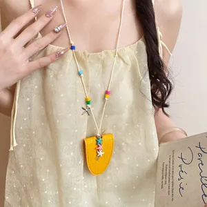 Detailed view of yellow leather starfish glasses clip necklace worn by a model.