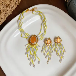 Barockes Schmuckset mit gelben Perlen, orangefarbenem Stein und passenden Perlenohrringen